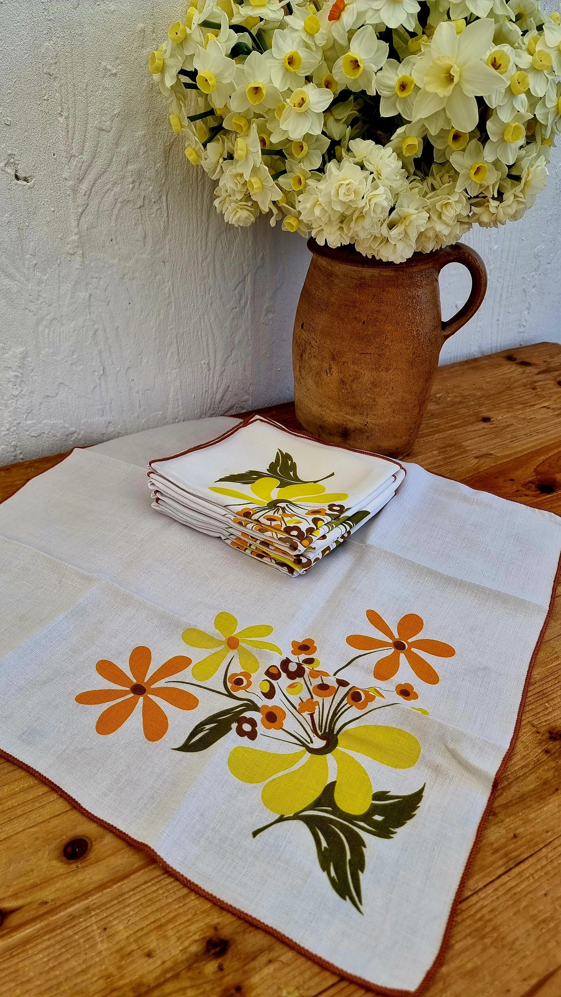 Set of 8 vintage 1970s table napkins with orange and yellow flowers.