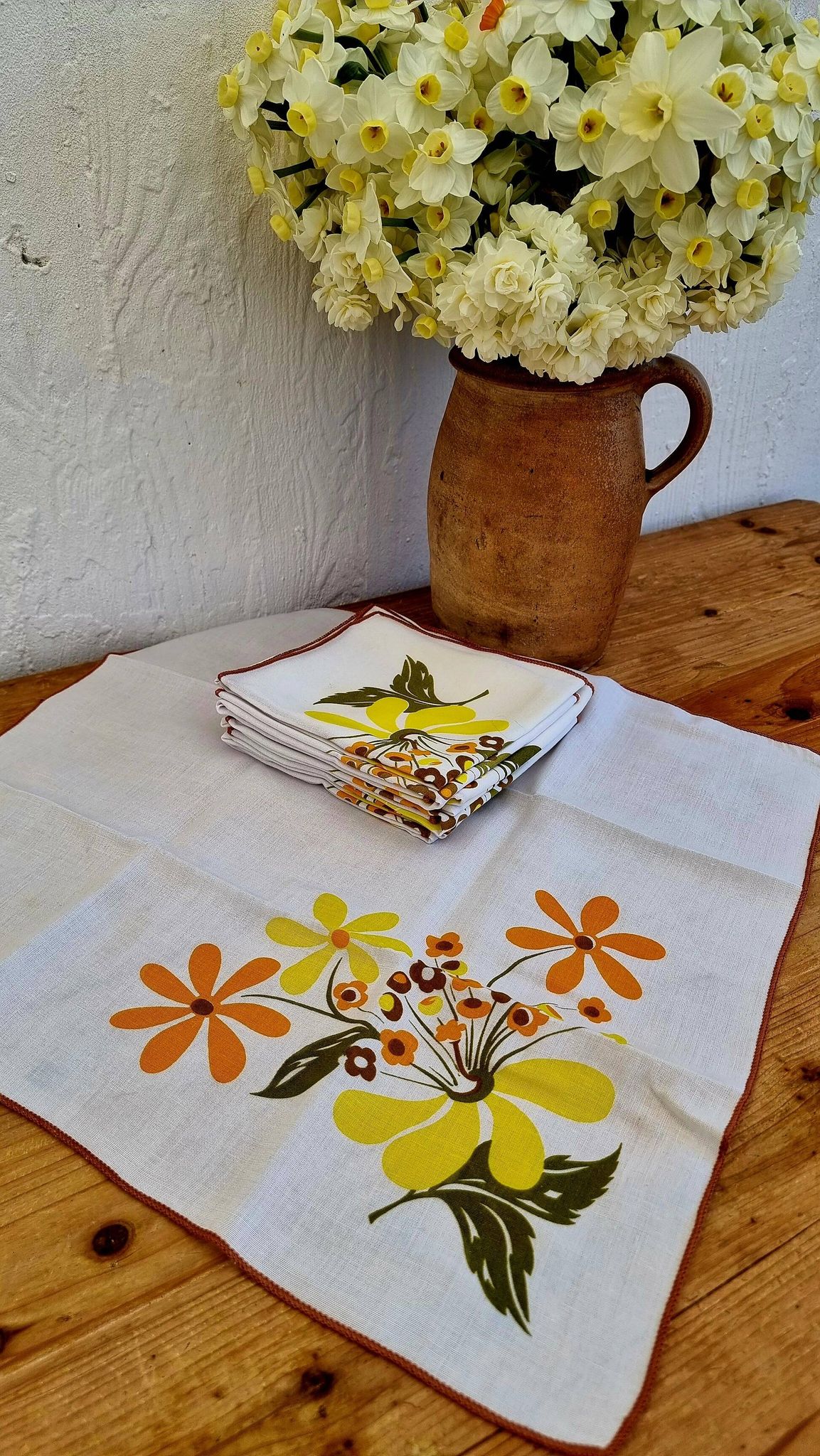 Set of 8 vintage 1970s table napkins with orange and yellow flowers.