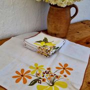Set of 8 vintage 1970s table napkins with orange and yellow flowers.
