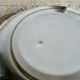 Shallow round metal plate with pearl row decoration.
