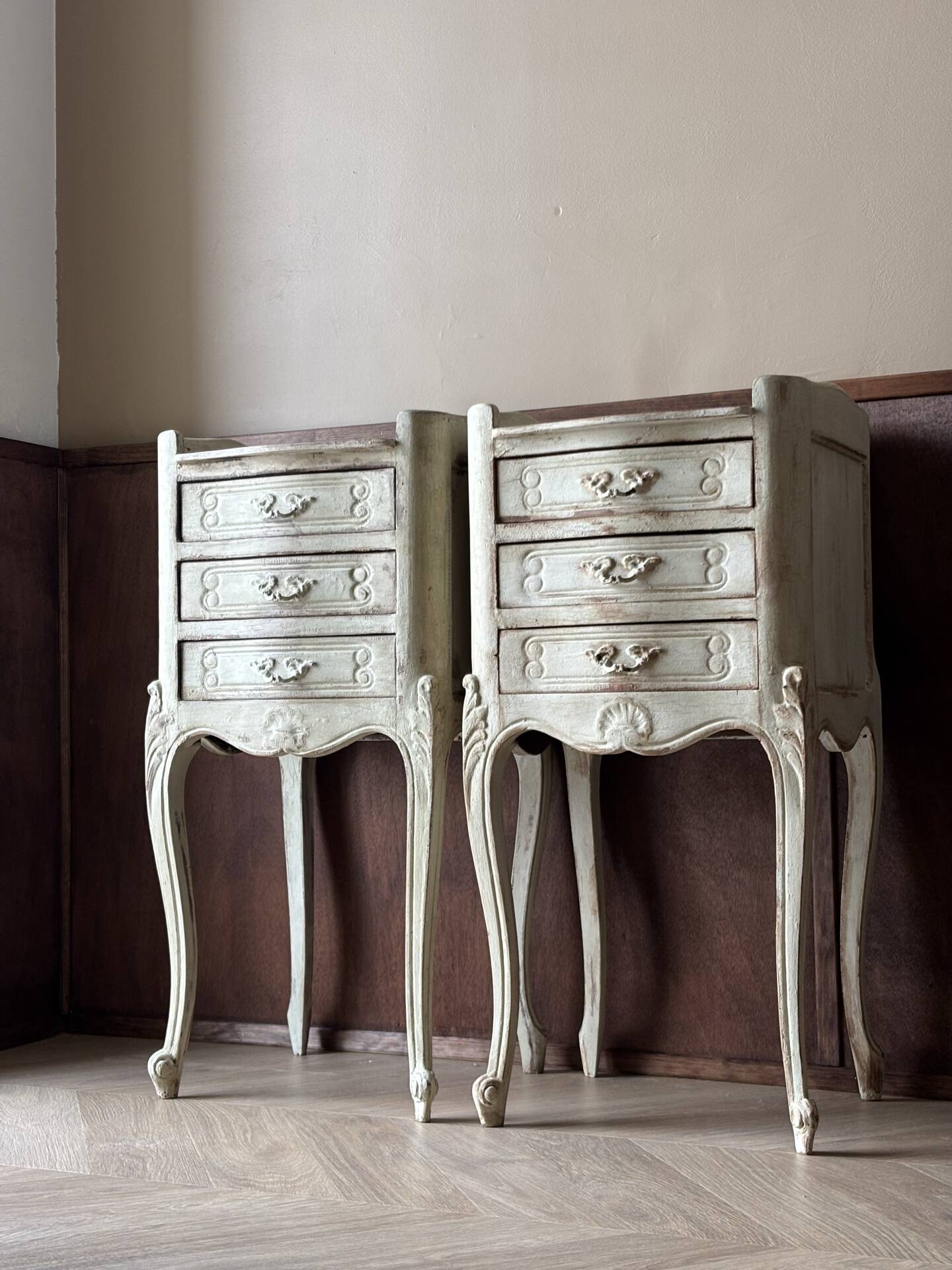 A pair of distressed bedside tables.