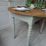 Walnut table with raised flaps, base on verdigris casters.