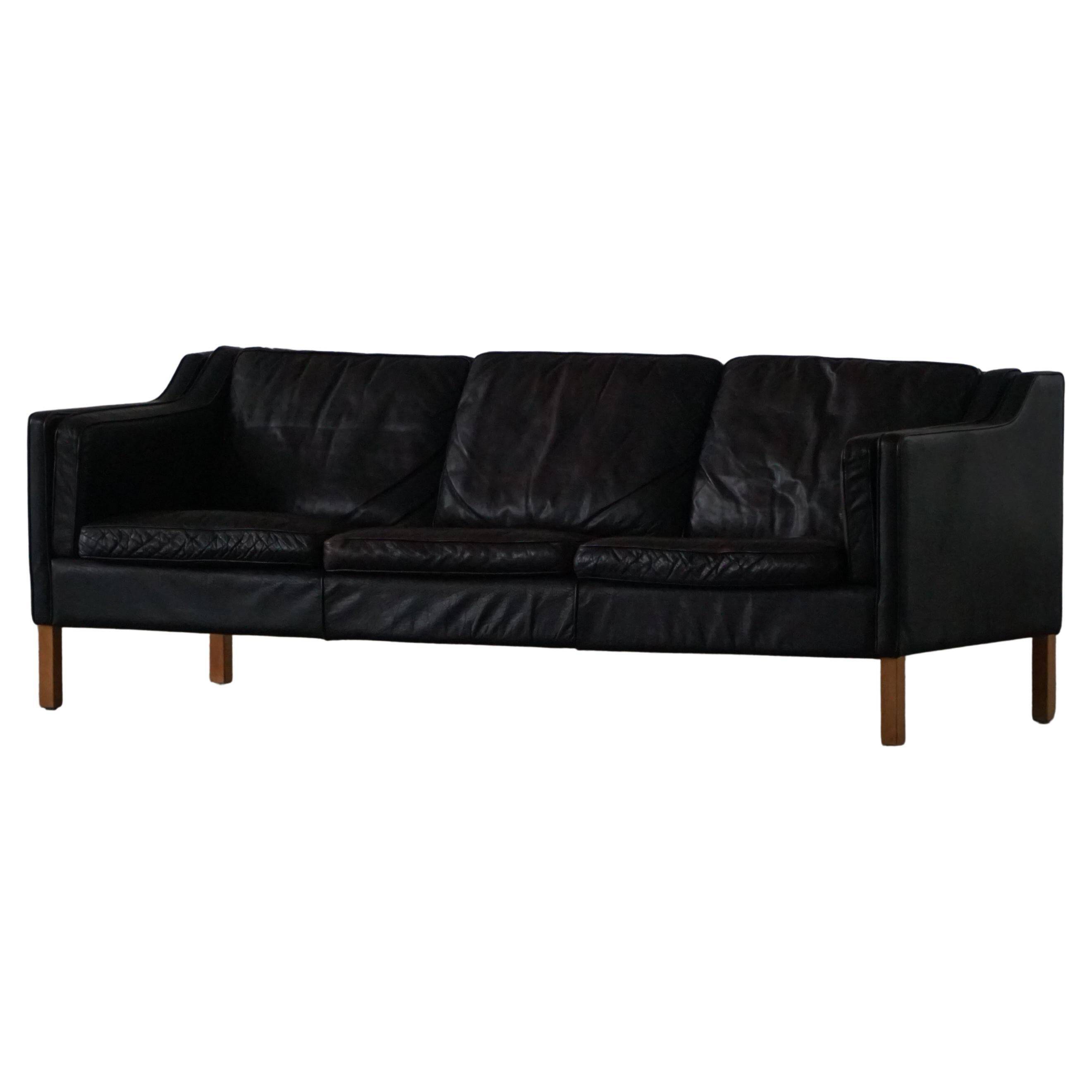 Three-seater canapé by Mogens Hansen, mid-century, in patinated black leather and solid beech.