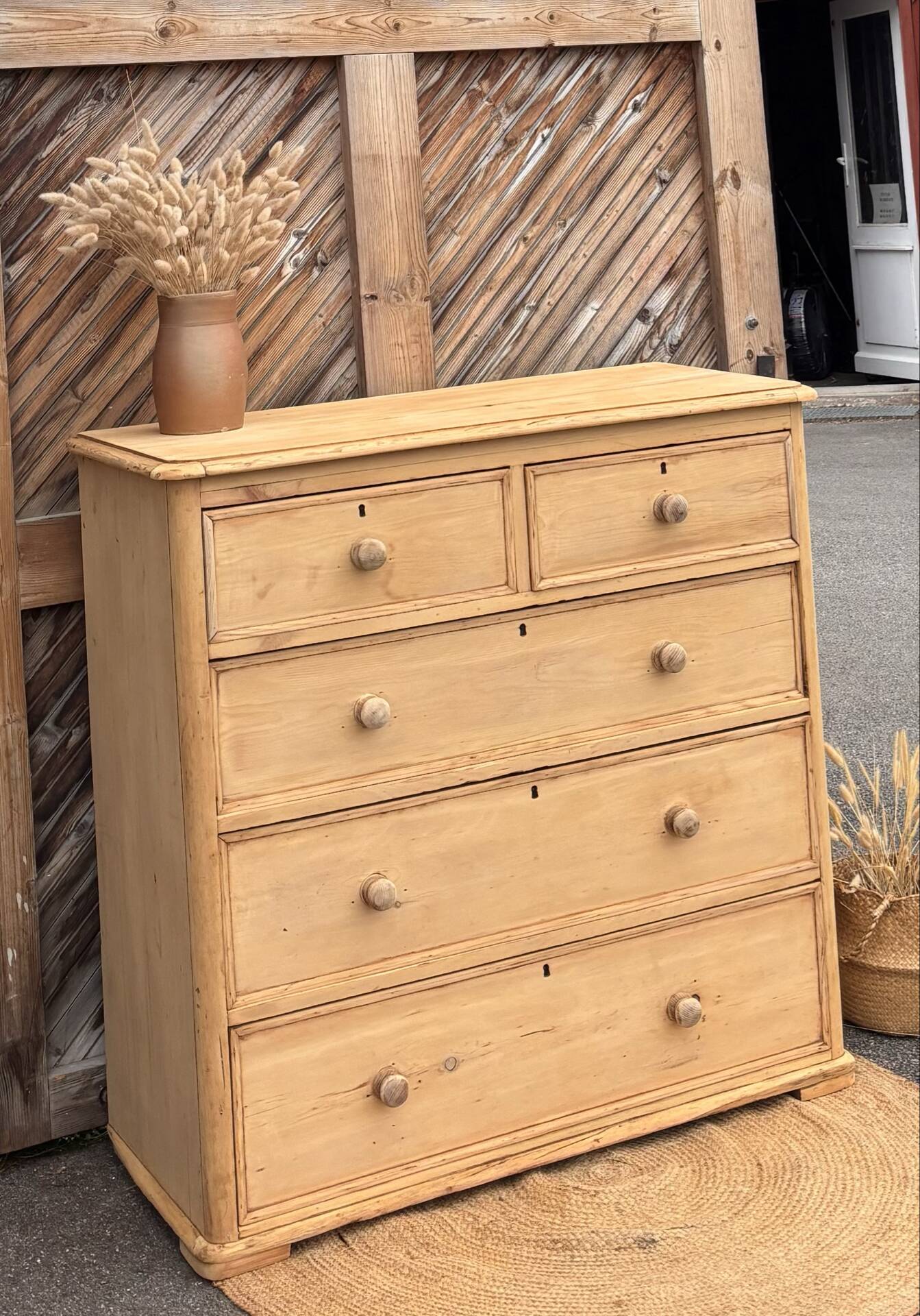 Large antique English chest of drawers in raw solid wood.