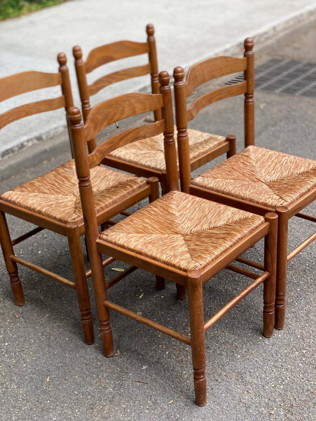 4 solid wood kitchen chairs with straw seats in a country farmhouse style.