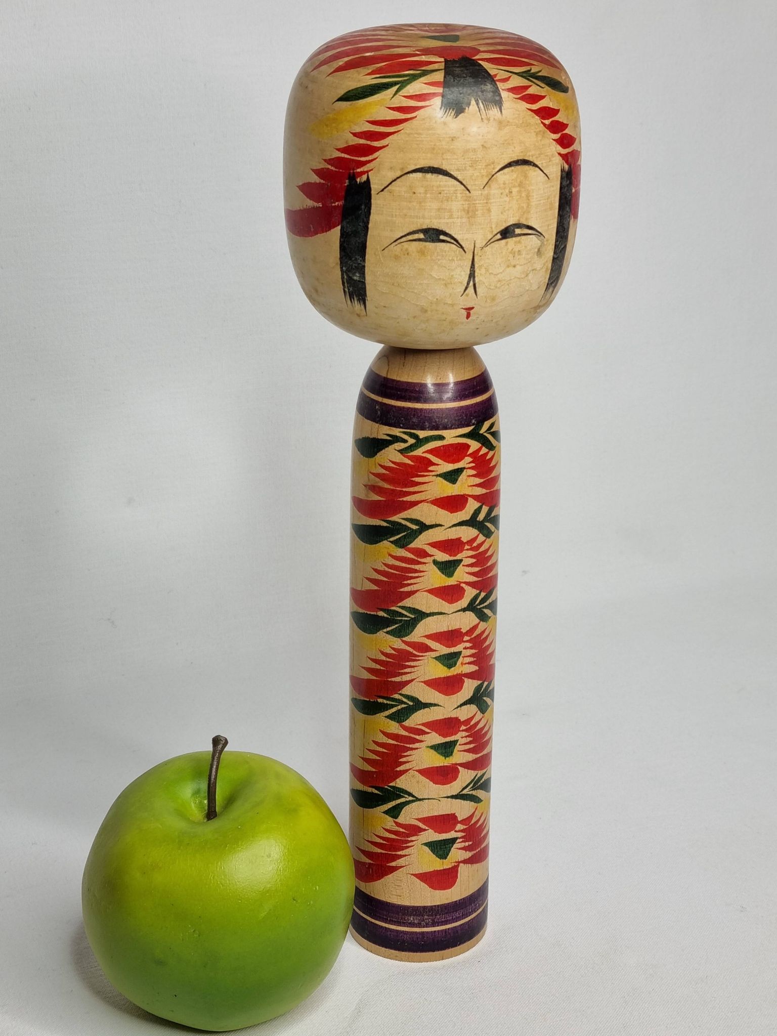 Japanese Kokeshi doll dated 1986, signed and numbered, hand-painted multi-colored floral decoration,