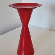 Vintage design candlestick in red metal in the shape of an hourglass