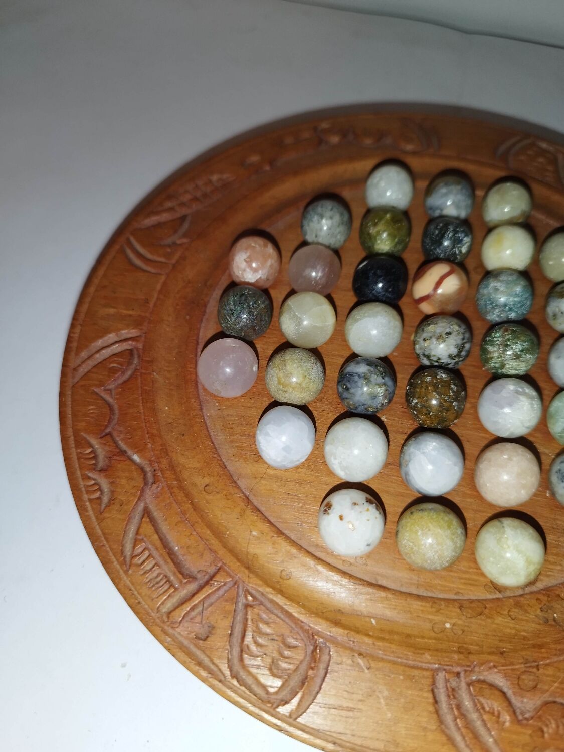 Ancient solitaire game in wood and stone marbles