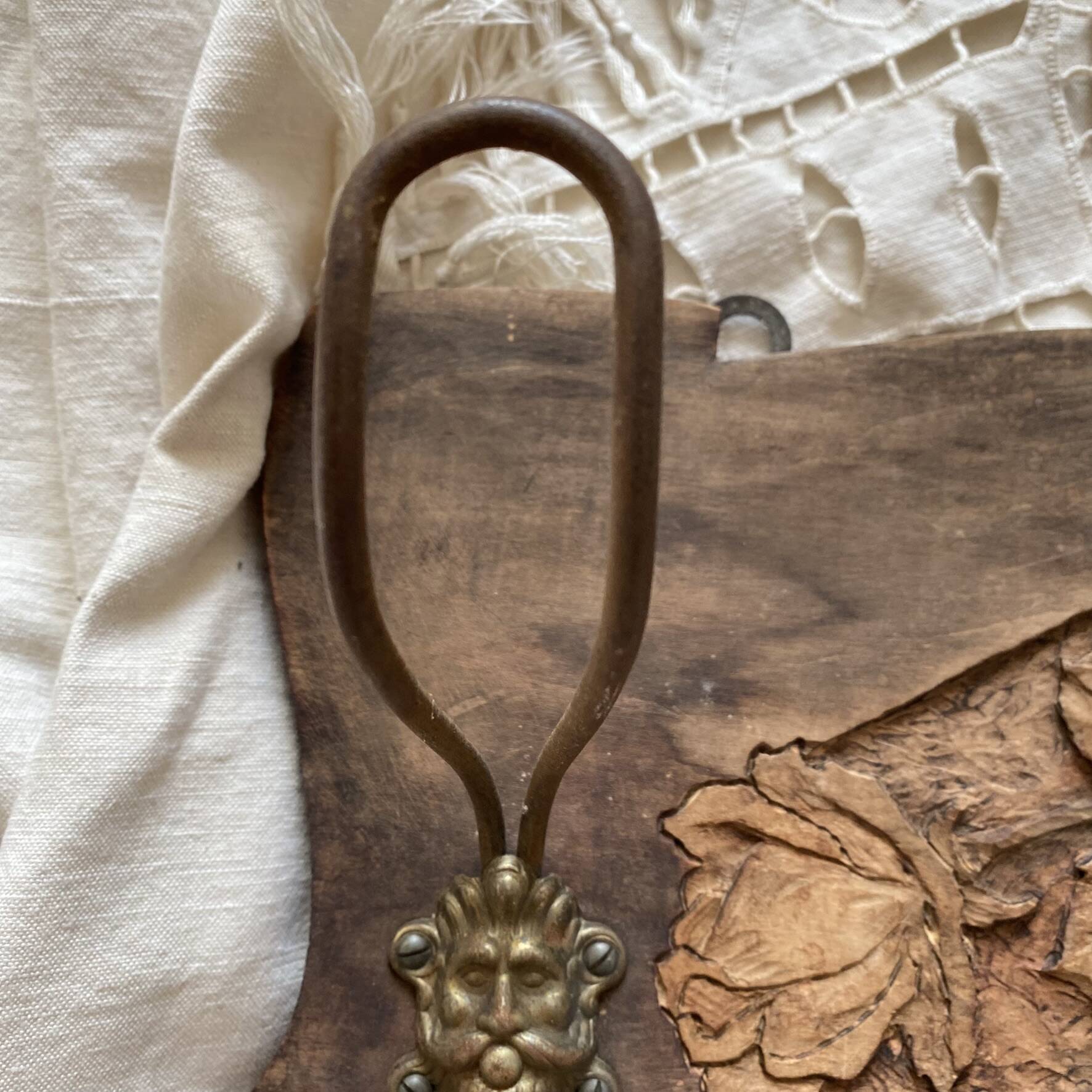 Wall-mounted coat rack in carved wood with rose decoration.
