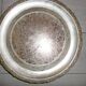 Large silver metal tray raised by a central foot