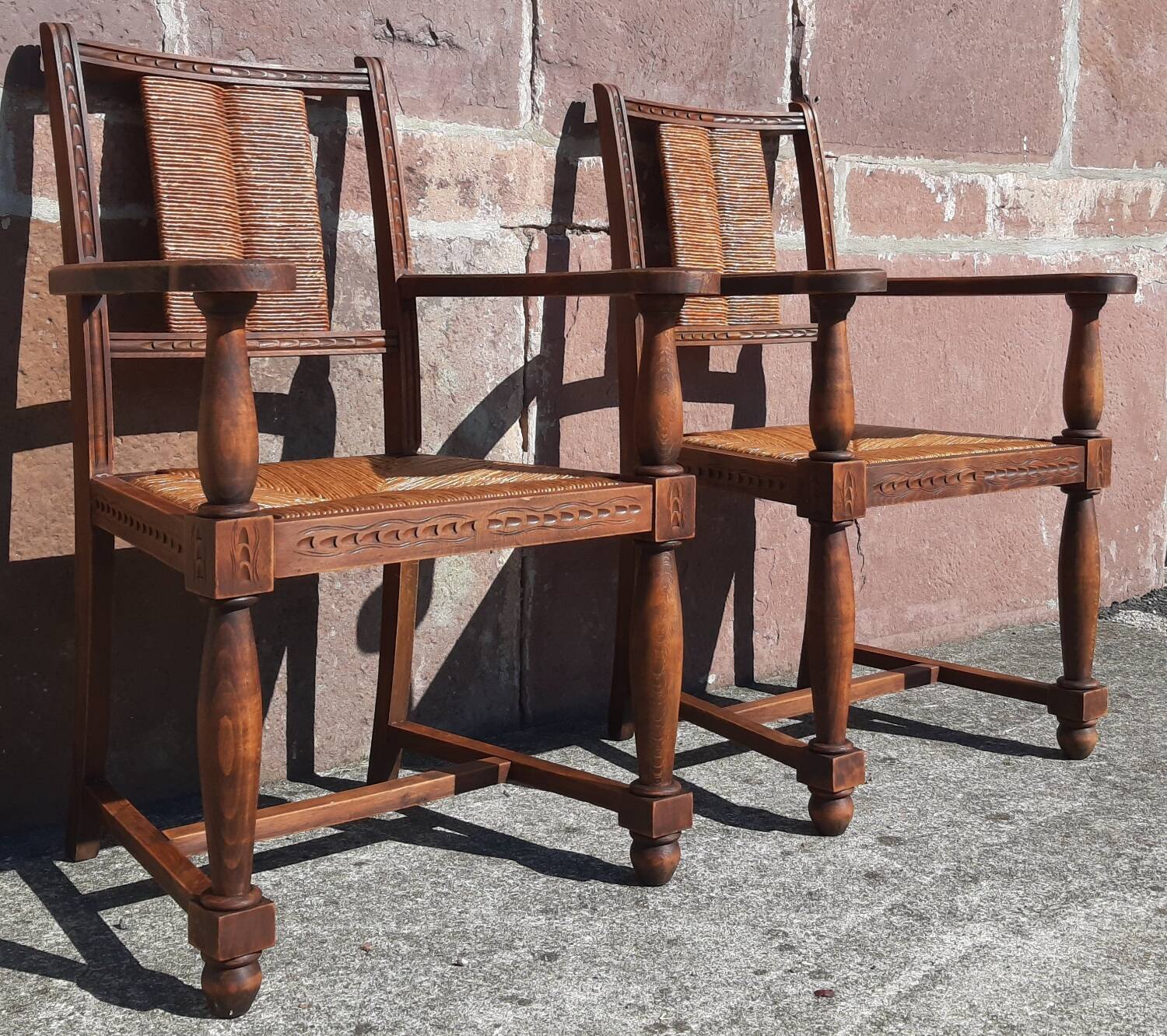 Pair of oak armchairs with straw seats and backs.