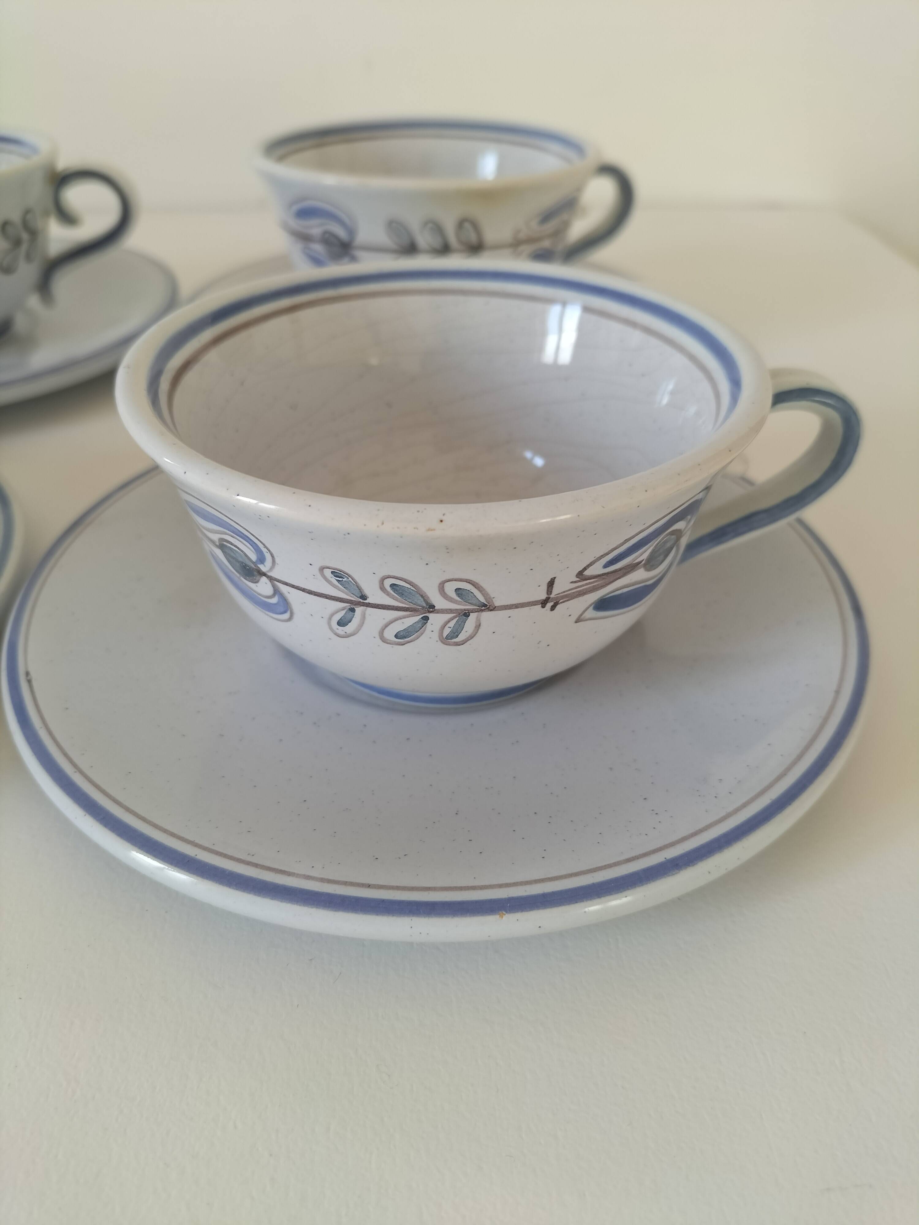 Glazed earthenware cups and saucers