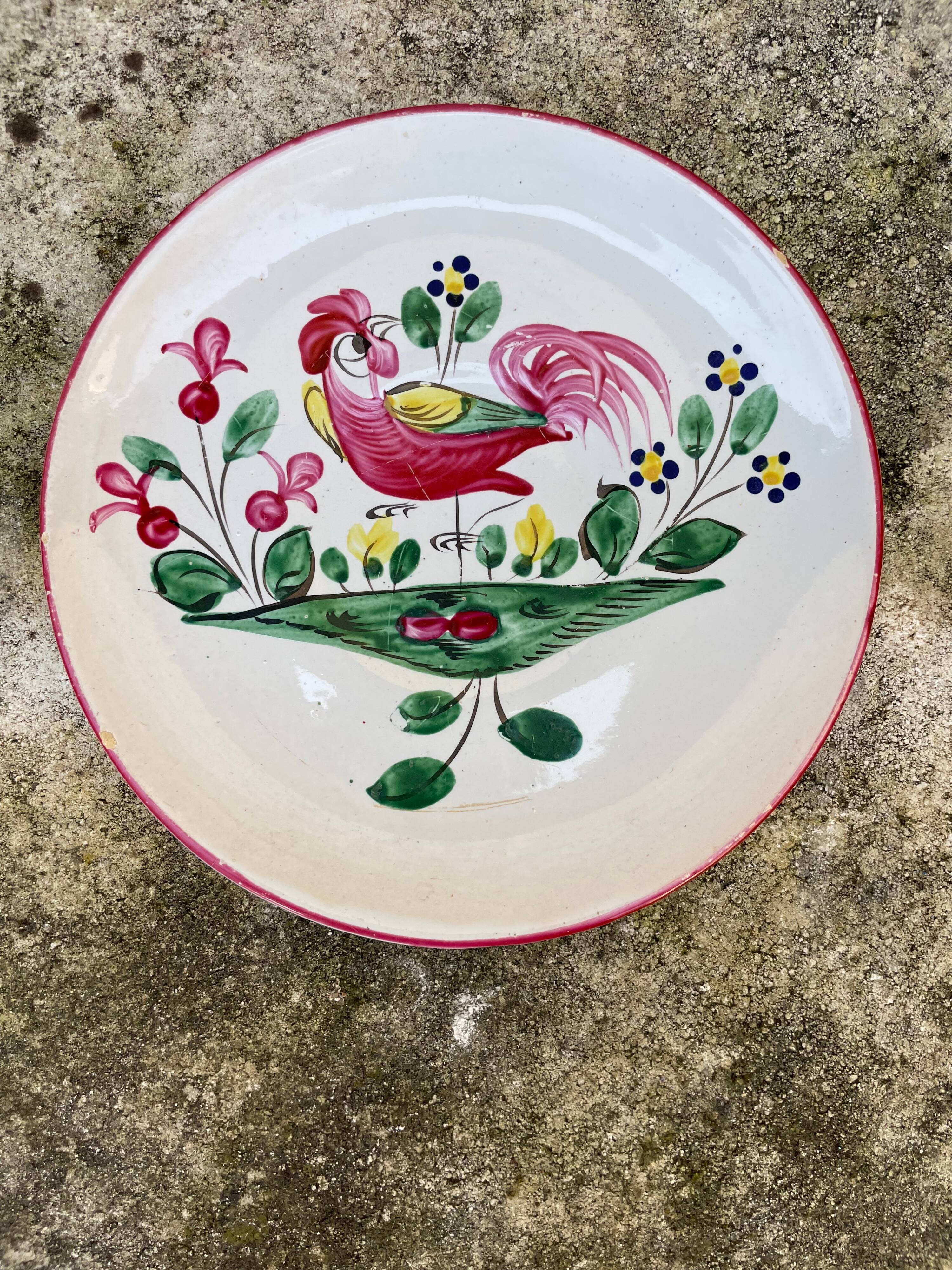 Antique plate with a flower and rooster pattern.