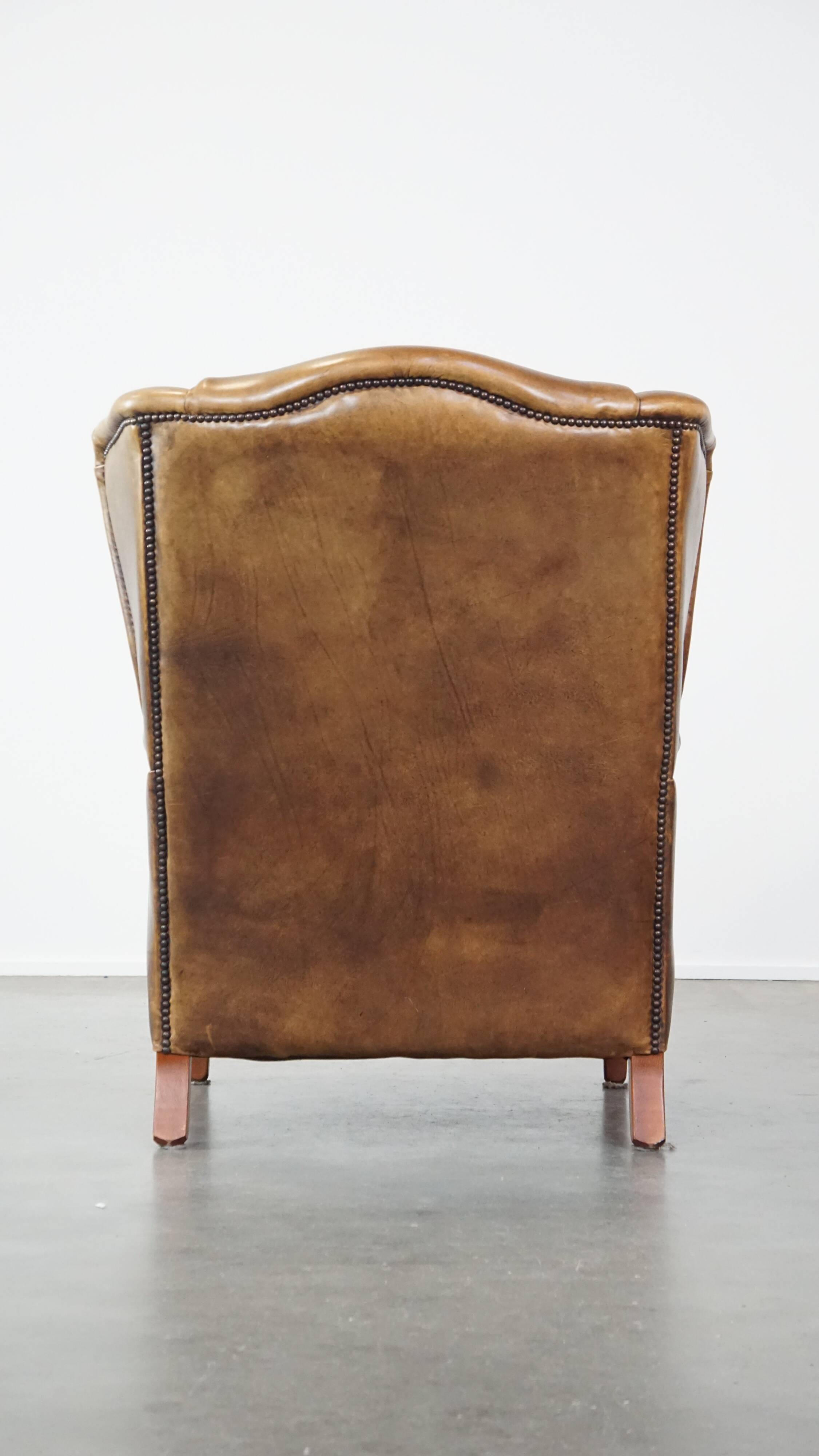 Charming sheep leather wingback armchair with a beautiful patina and excellent seating comfort