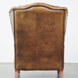Charming sheep leather wingback armchair with a beautiful patina and excellent seating comfort