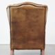 Charmant fauteuil à oreilles en cuir de mouton avec une belle patine et un excellent confort d'assise