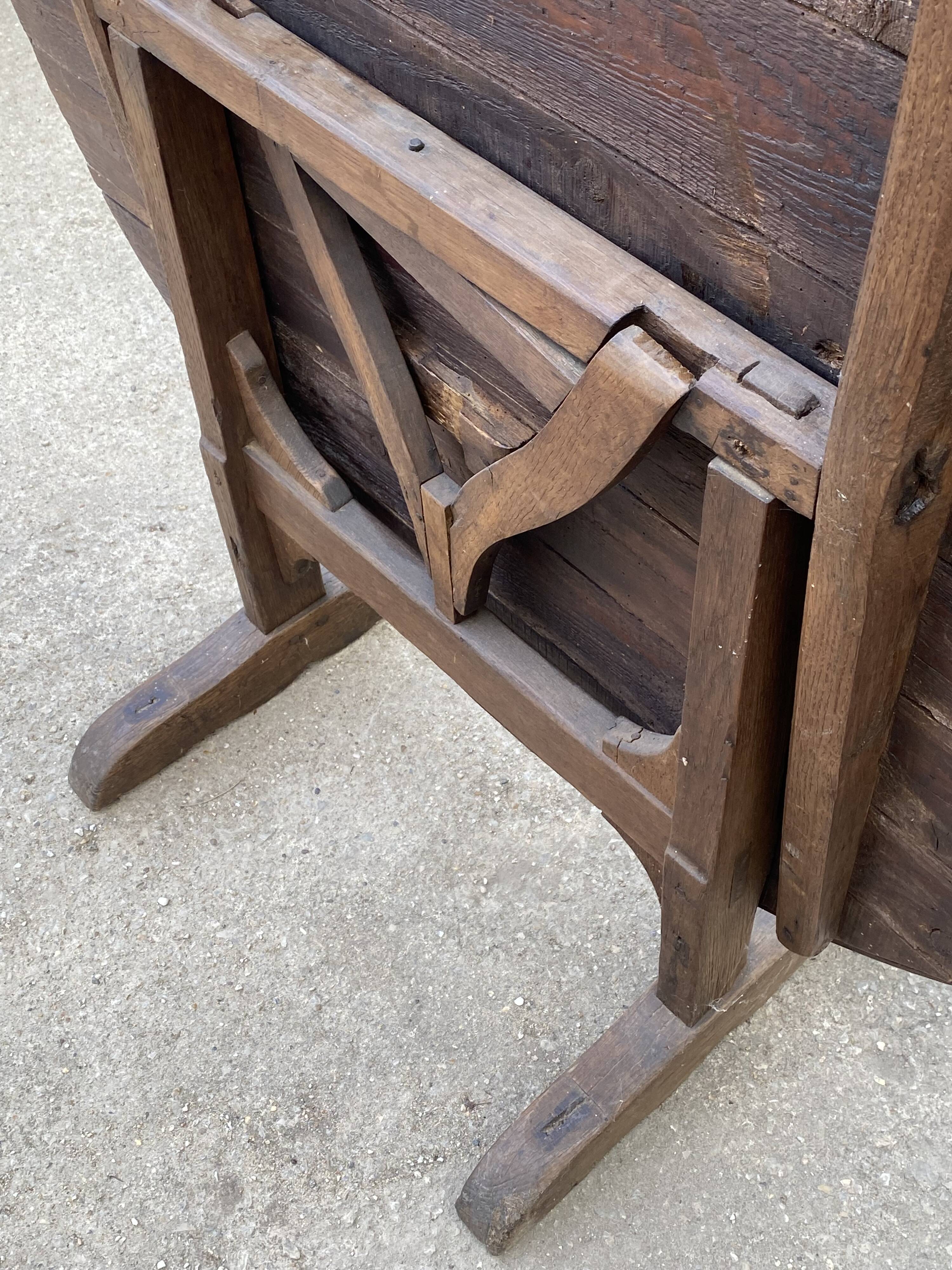 Old folding round winemaker's table with a tilting top.
