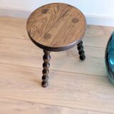 Small wooden tripod stool with turned legs, country style.
