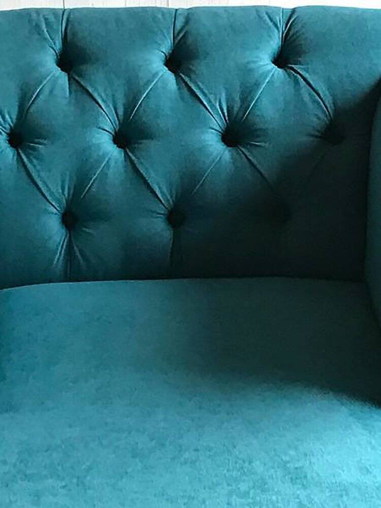 Mid-century turquoise blue fabric sofa with solid oak legs and tufting.