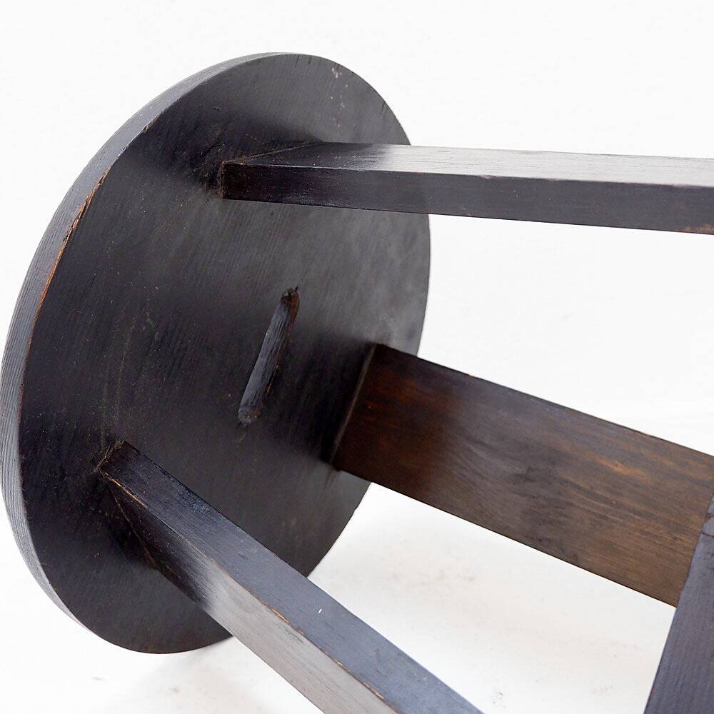 Vintage black-stained wooden tripod stool with mortise joints.