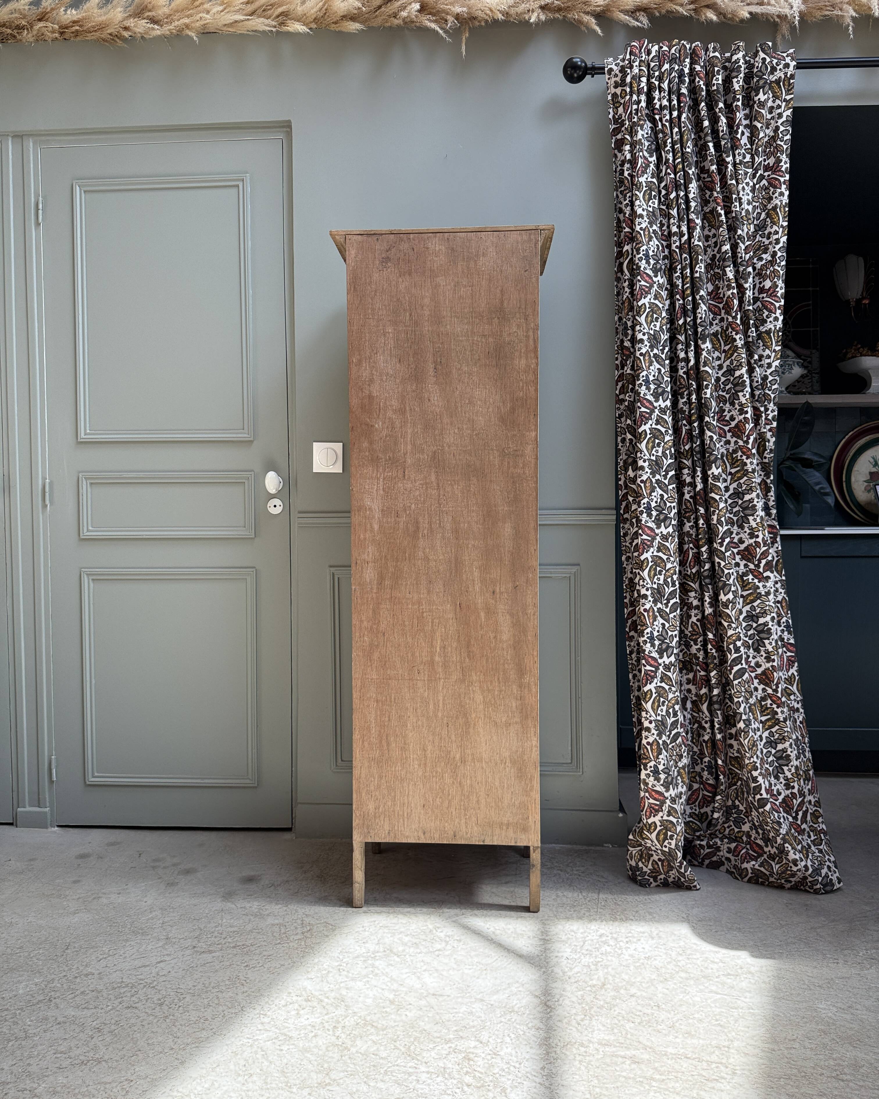 Column storage unit with a sculpted metal door.