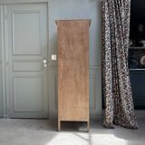 Column storage unit with a sculpted metal door.