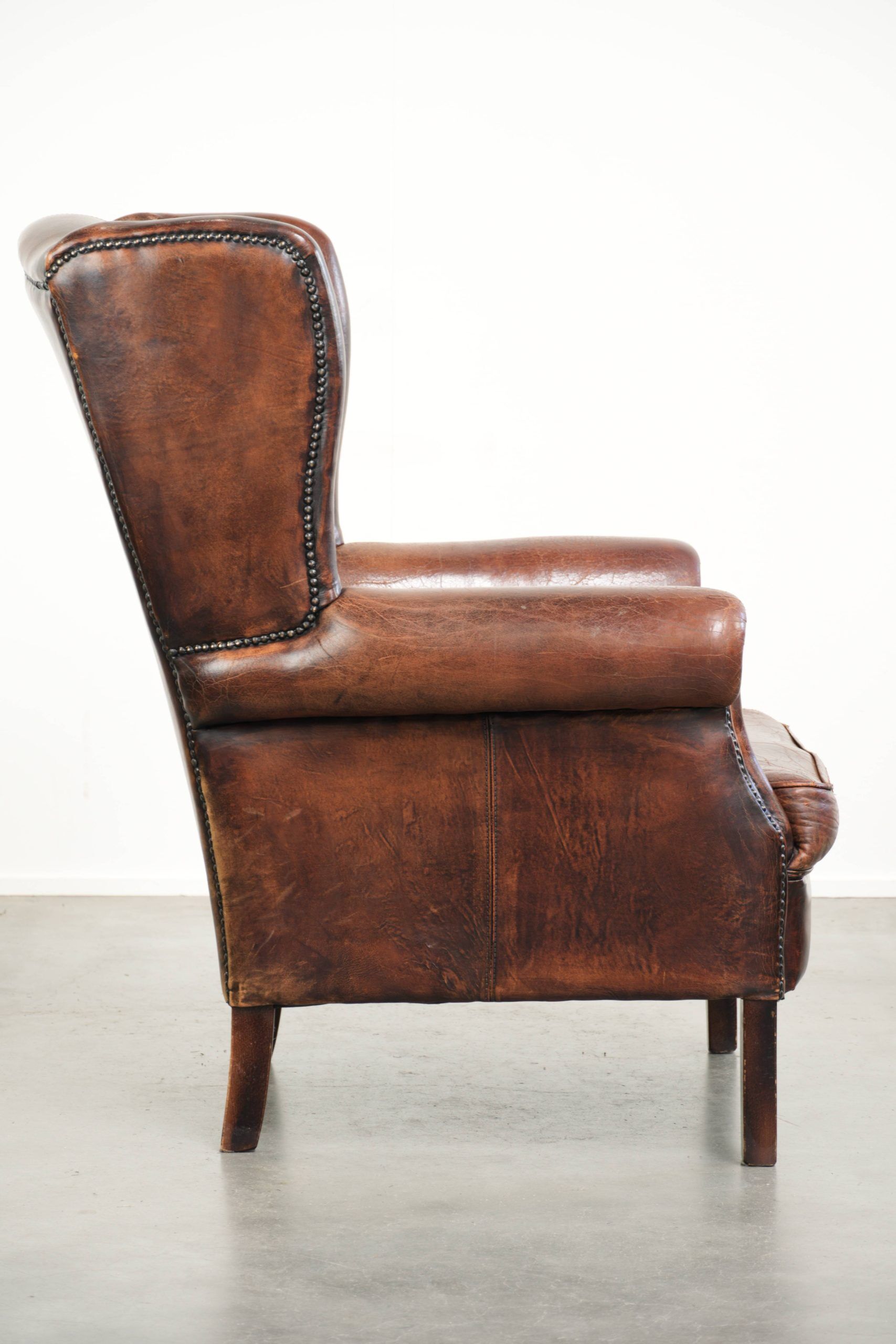 Vintage sheepskin wingback armchair in a deep brown colour finished