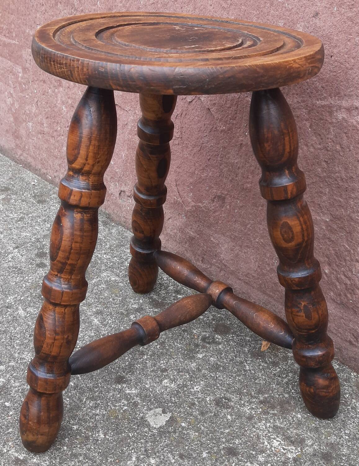 Low wooden tripod stool.
