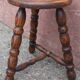 Low wooden tripod stool.