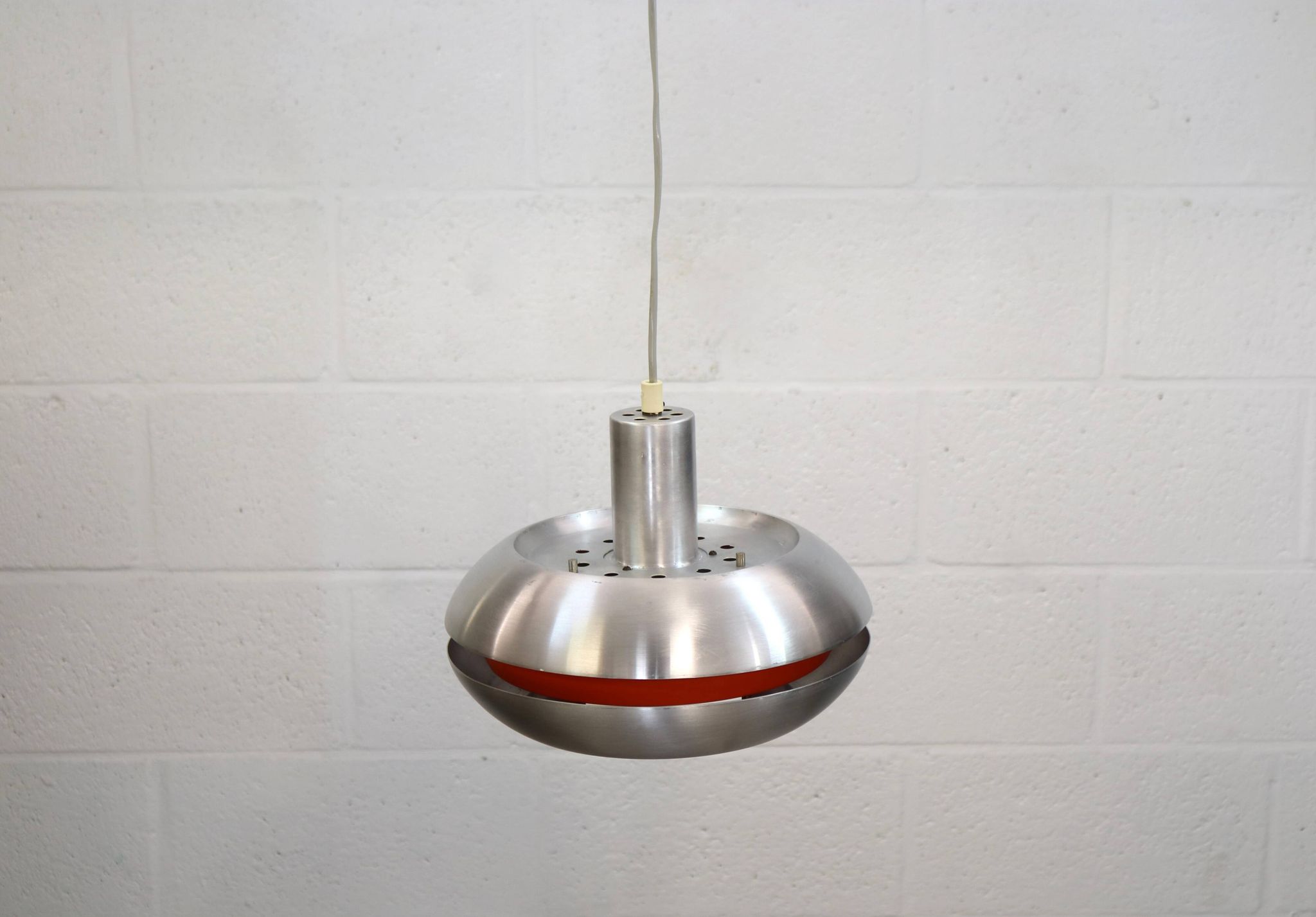 Ancienne lampe de design danois de l'ère spatiale en aluminium avec intérieur orange.