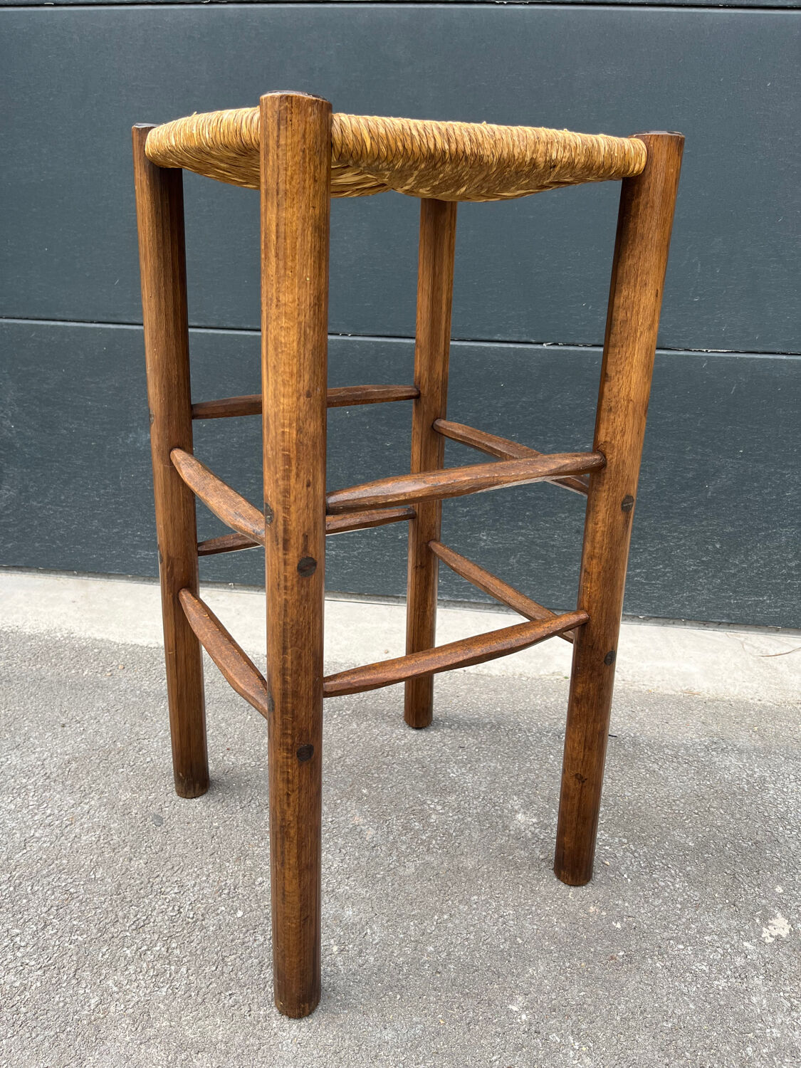 Old high bar stool in wood and straw