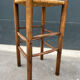 Old high bar stool in wood and straw