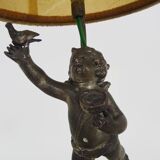 Old table lamp in repel, cherub, angel, cherub, putti with a bird in hand. 1930s
