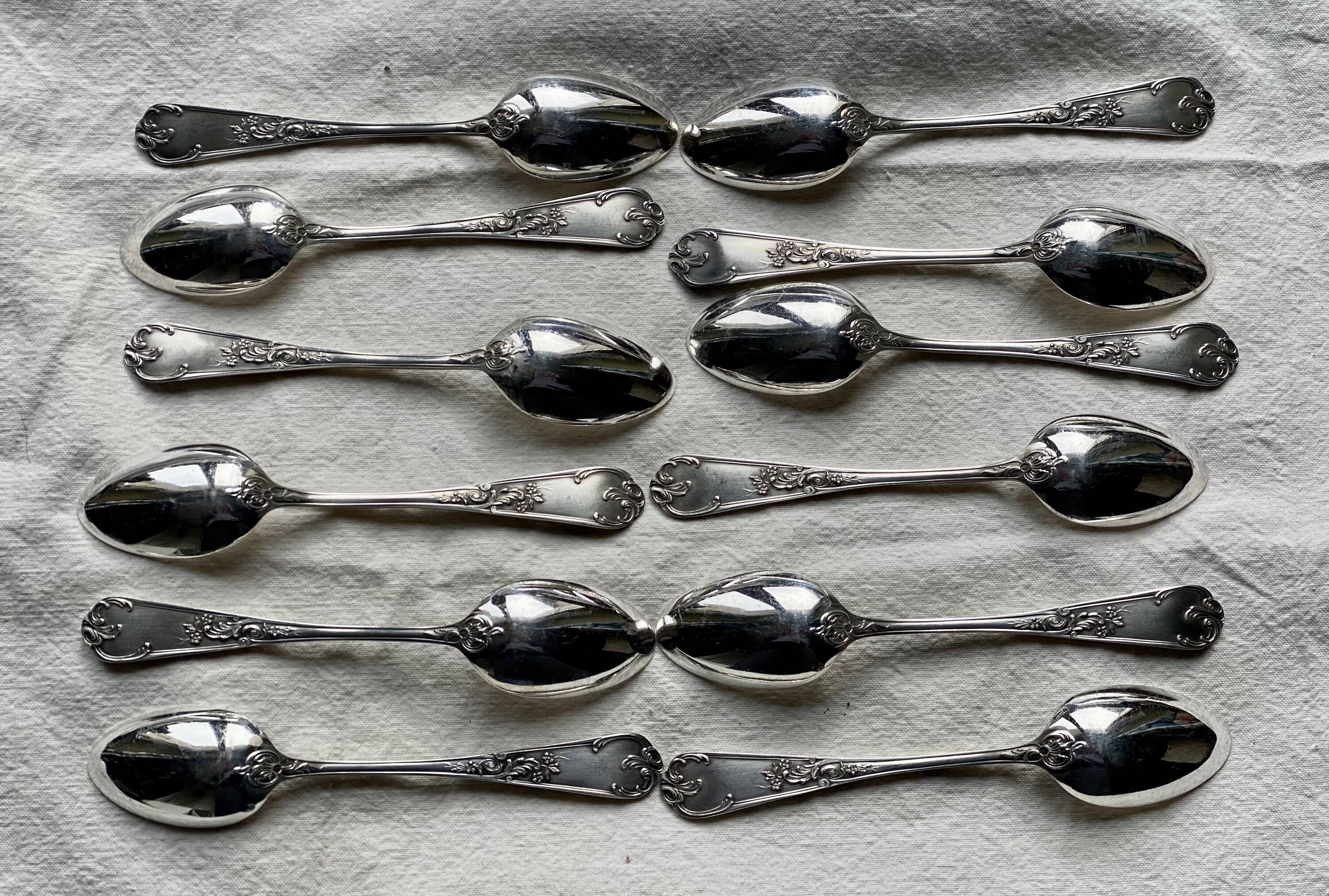 Set of 12 small silver-plated metal spoons in Art Nouveau style.