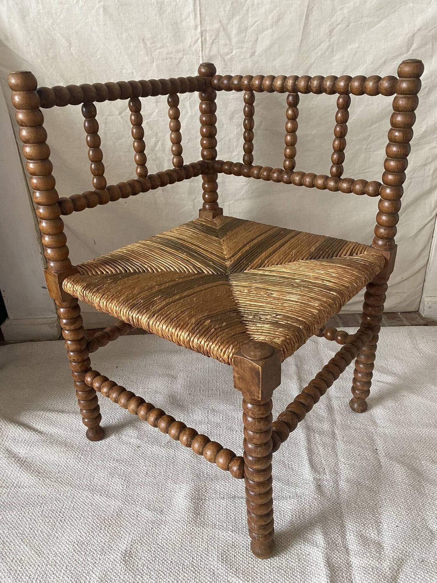 Corner chair in straw and turned wood, fireside chair.