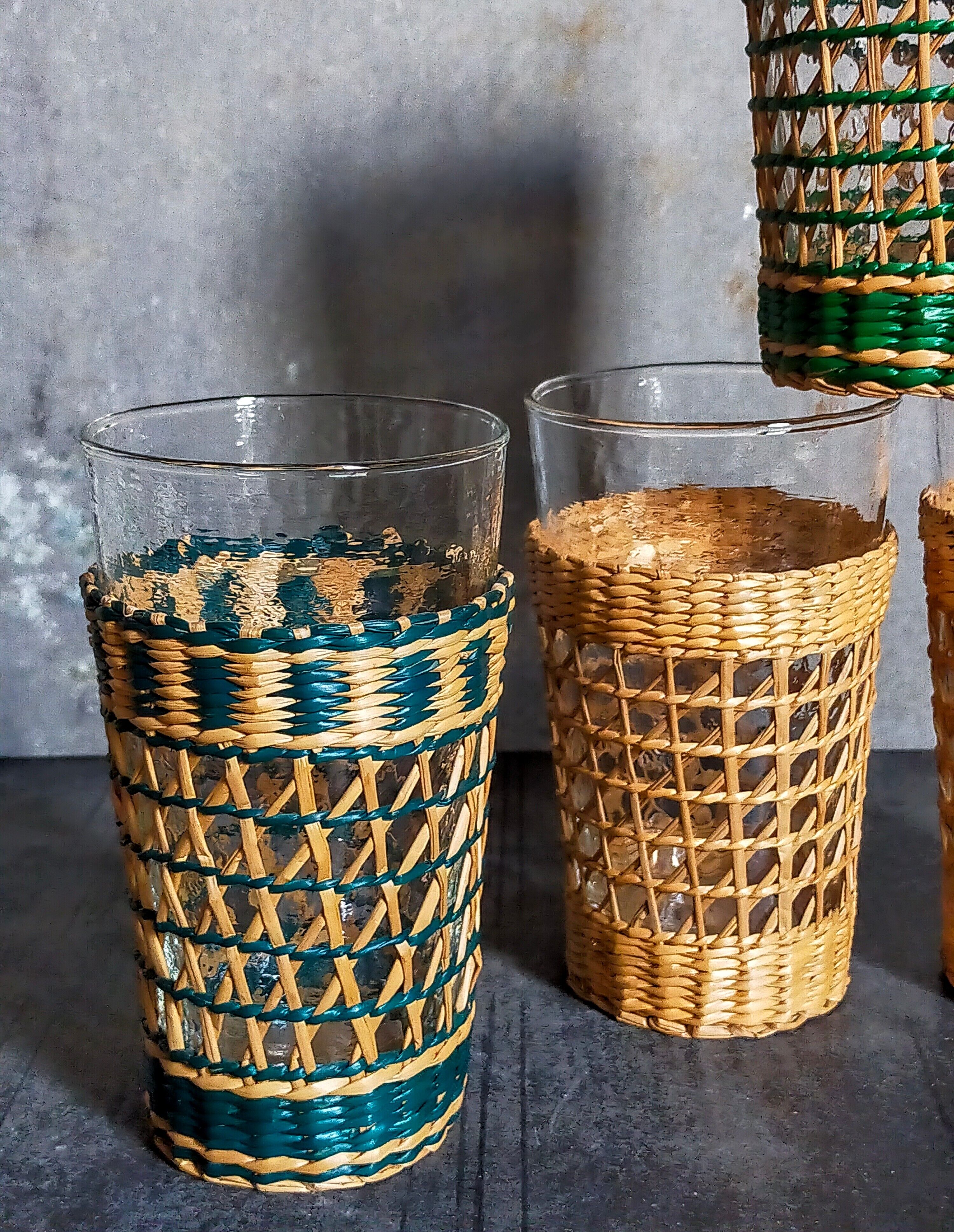 Four long drink glasses in vintage woven rattan cases