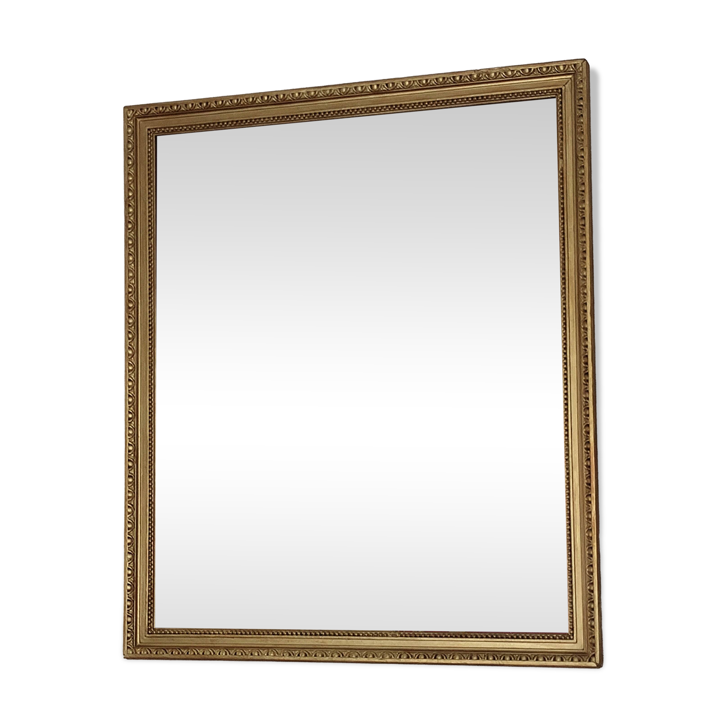 Antique mirror with a gilded frame and beaded border.