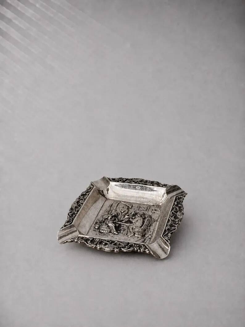 Antique silver-plated ashtray, decorated with repoussé scenes of a tavern, pin tray.