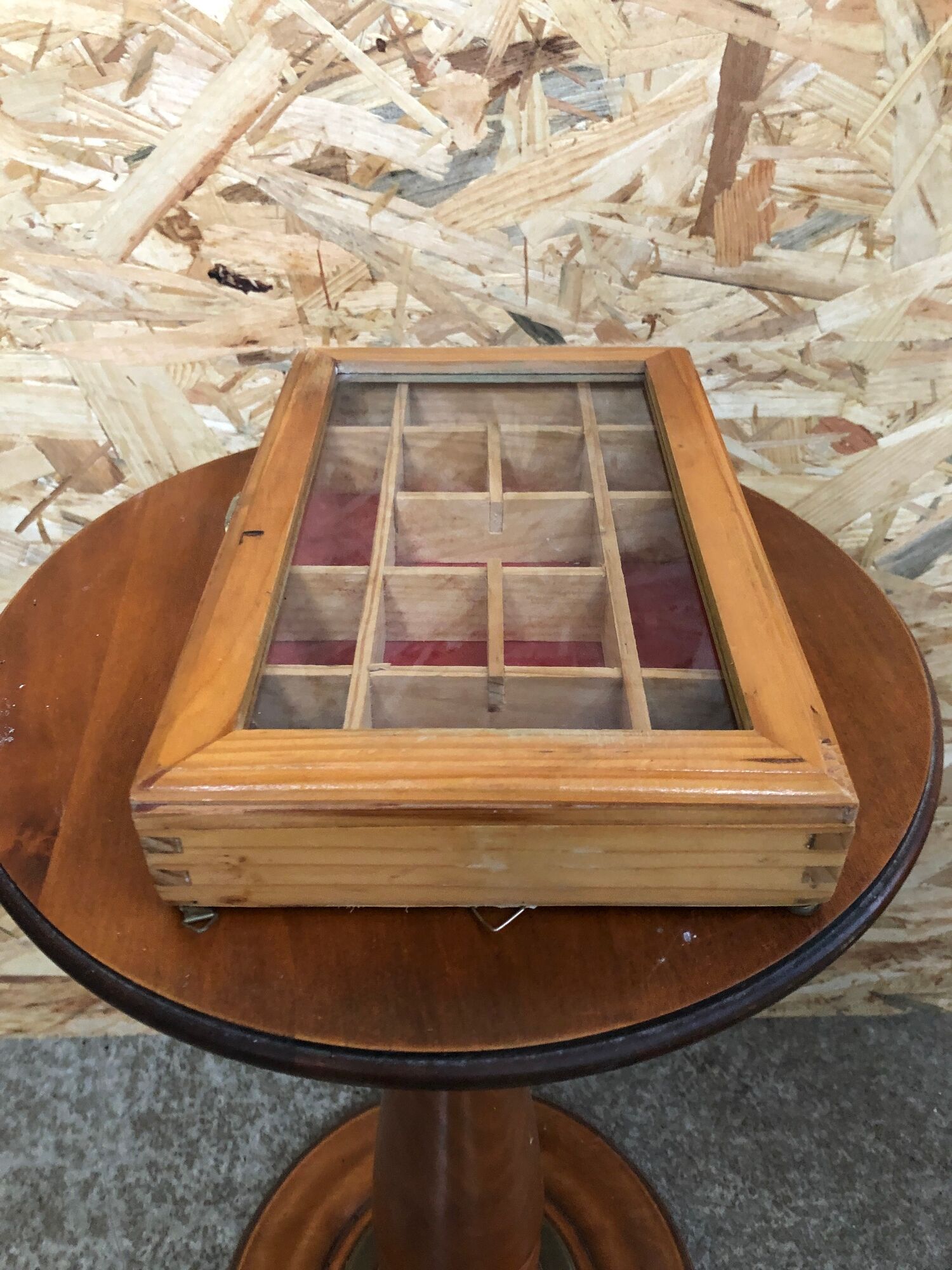 Old hanging display case with 15 wooden boxes, red background + vintage glass door