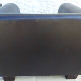 2 club armchairs with a chocolate faux leather seat and backrest and wooden legs.