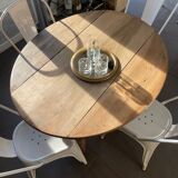 Oval wooden table with drop-leaf edges.