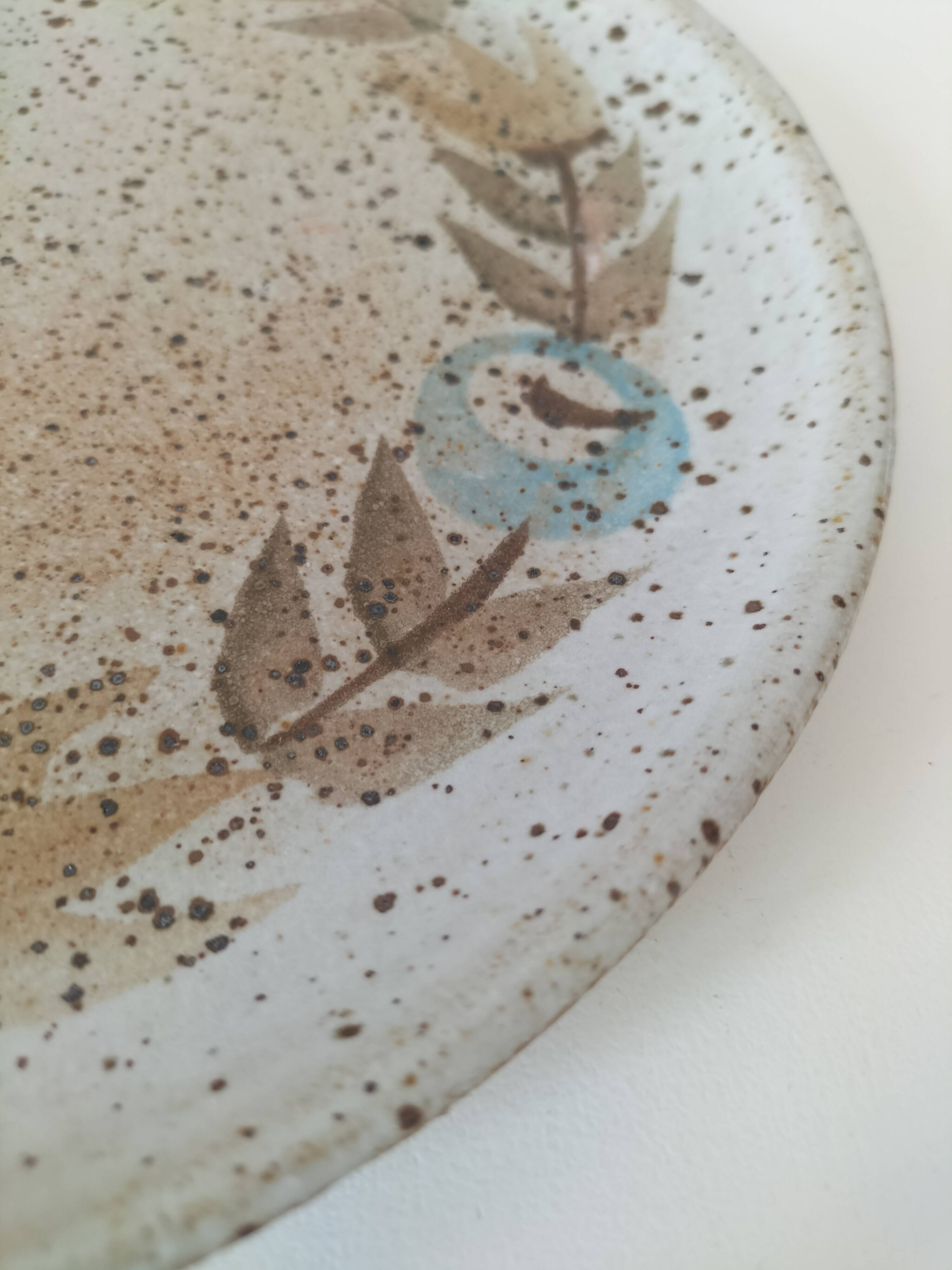 Speckled stoneware plate with floral decoration