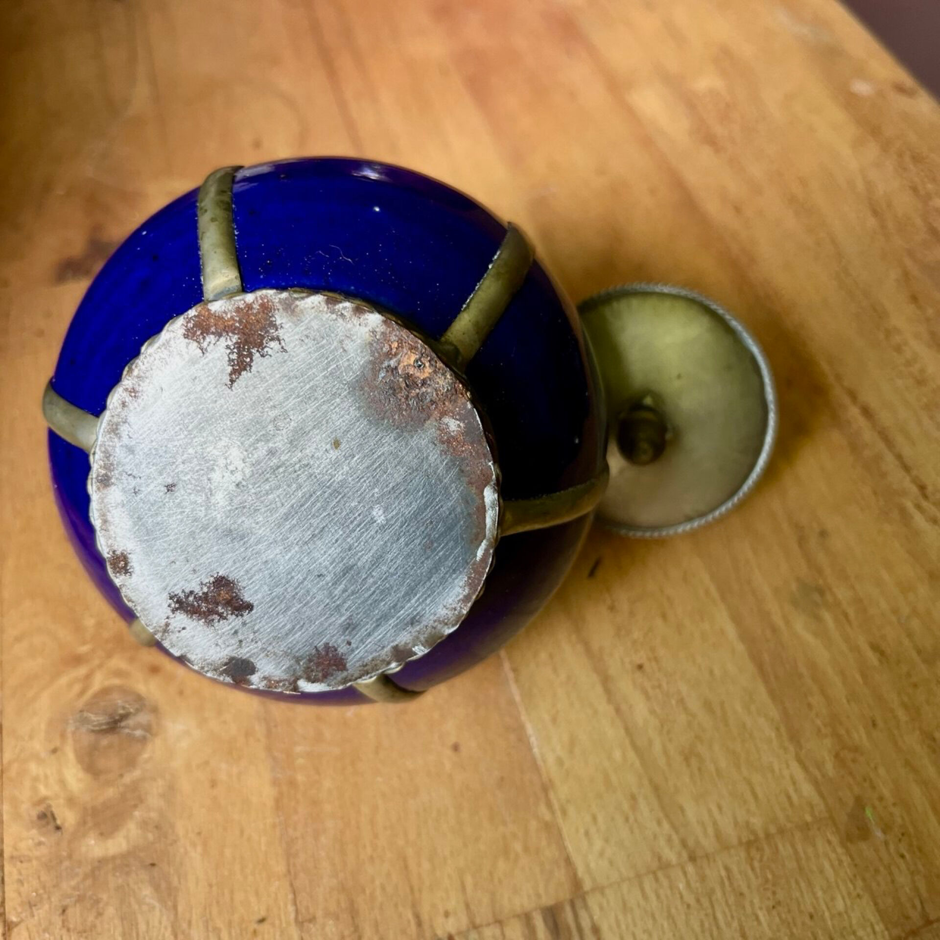 Small blue ceramic pot with metal frame and lid.