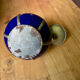 Small blue ceramic pot with metal frame and lid.