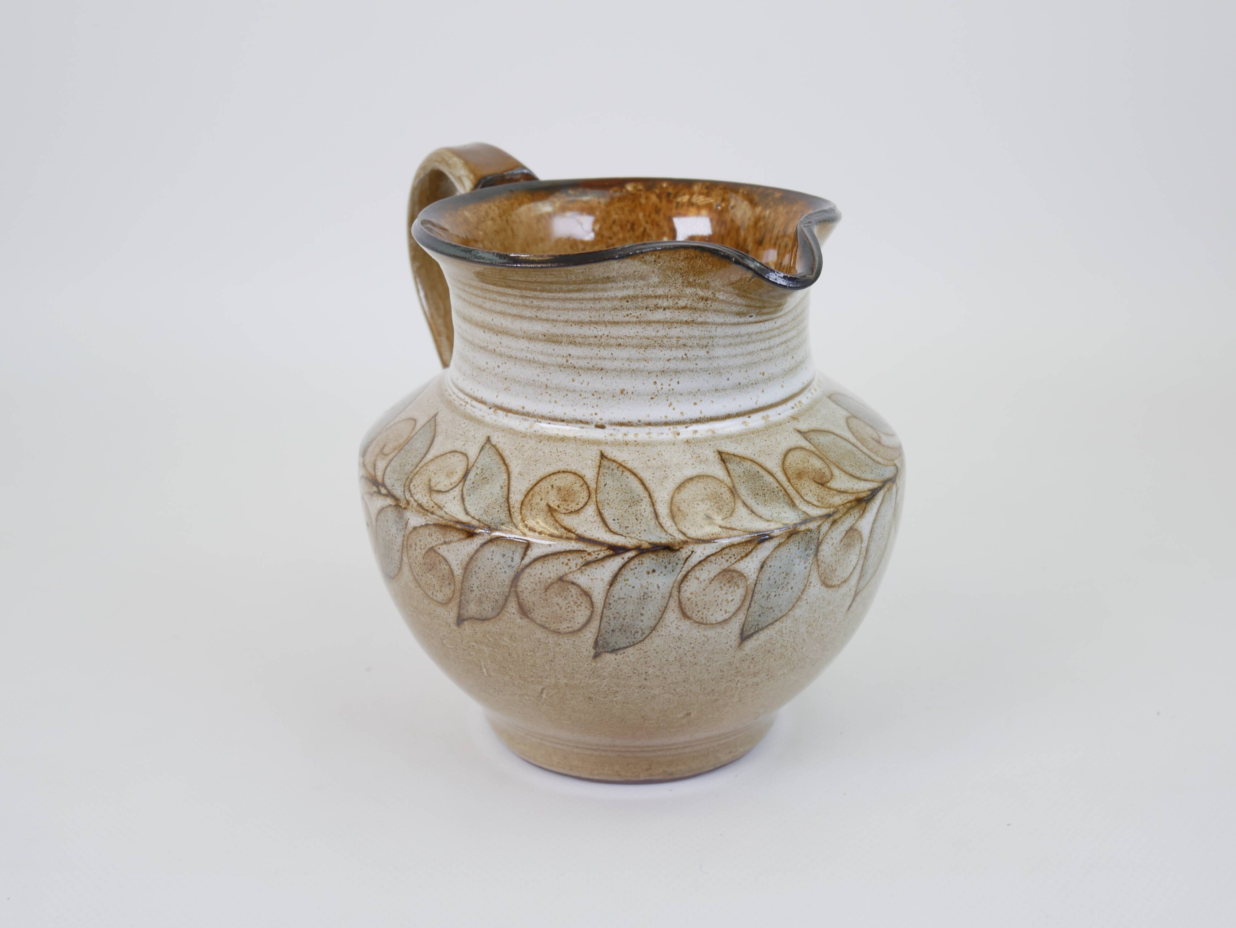Glazed ceramic jug with plant decoration