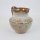 Glazed ceramic jug with plant decoration