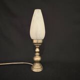 Old bronze or brass table lamp from the early 20th century with white streaked flame glass globe
