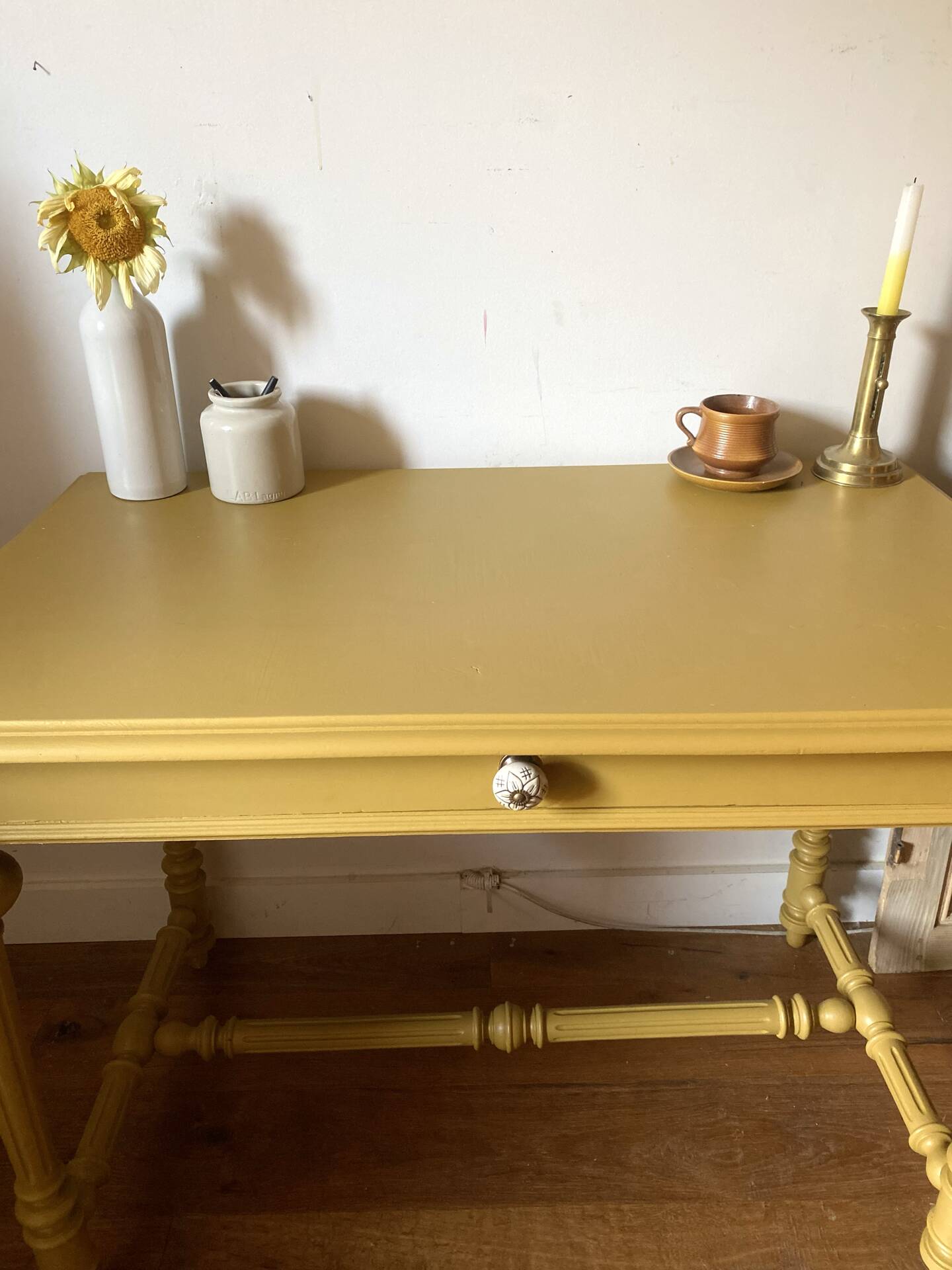 Desk table from the late 19th century, painted mustard, with turned stretcher.