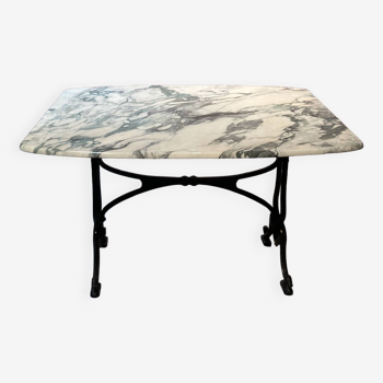 Cast iron base table with white marble top, a brand is present "DAD"