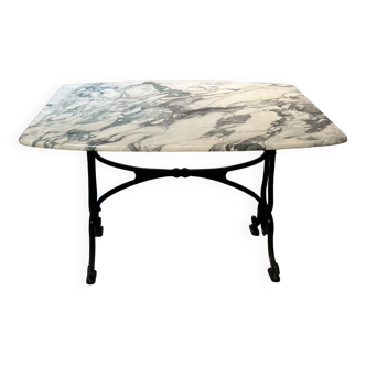 Cast iron base table with white marble top, a brand is present "DAD"